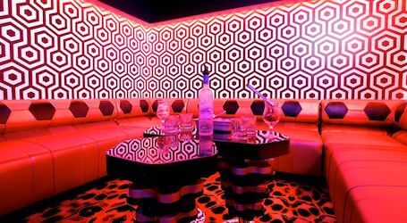 private booth in strip club with bottle of vodka