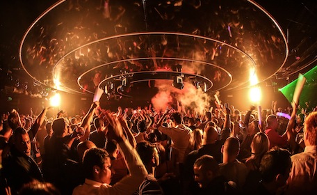 crowd partying at nightclub with lights and smoke