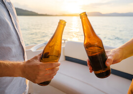 two bucks cheers beers on back of boat and sunset