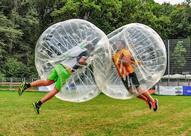 two stags jumping at each other playing bubble soccer