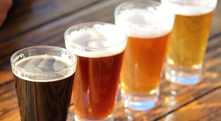 four beers lined up at bar