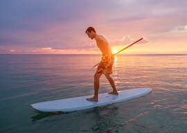 buck stand up paddle boarding at beach