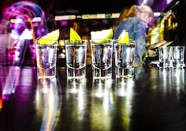 four shots of alcohol on nightclub bar with lemon on top