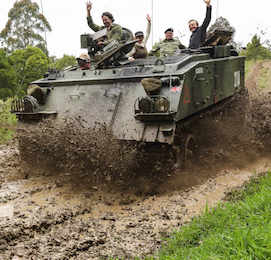 bucks riding in army tank as mud splashes
