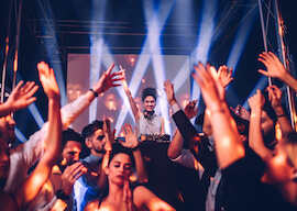 female dj playing to dancing crowd at party