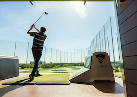 buck swinging club at top golfing range