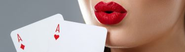 woman with redlip stick holding two aces