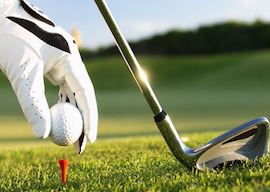 buck putting golf ball on tee with club