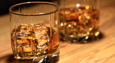 two glasses of rum on wooden table