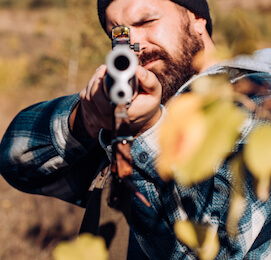 buck holding a shotgun ready to shoot