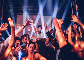 dj in nightclub with crowds dancing