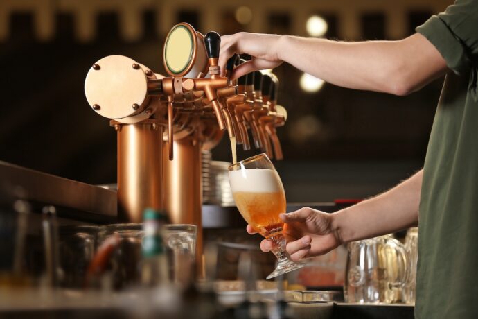 man is pouring beer from beer tap