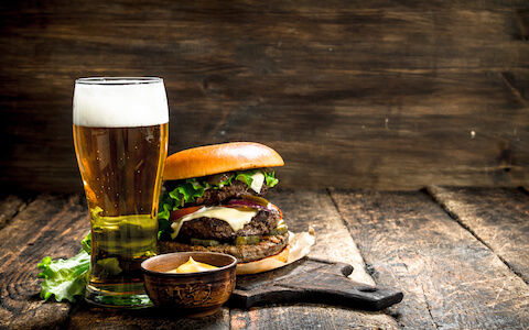 big burger and beer on wooden palate