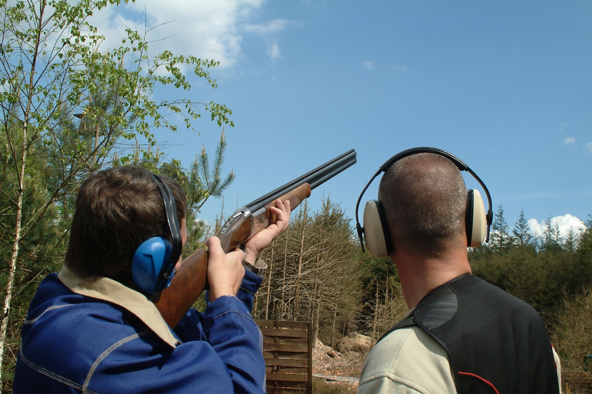 two men aim at clay pigeon shooting