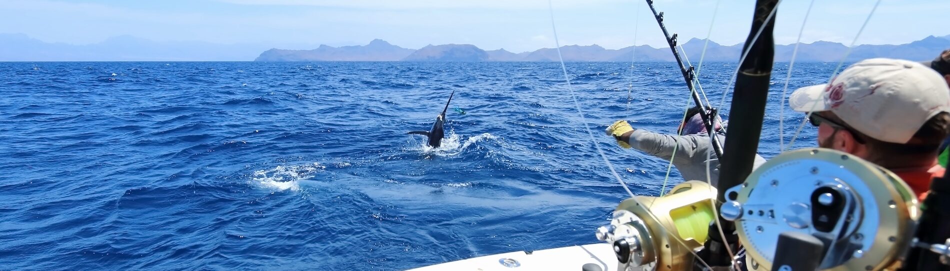 man fishing in the deep sea off a boat