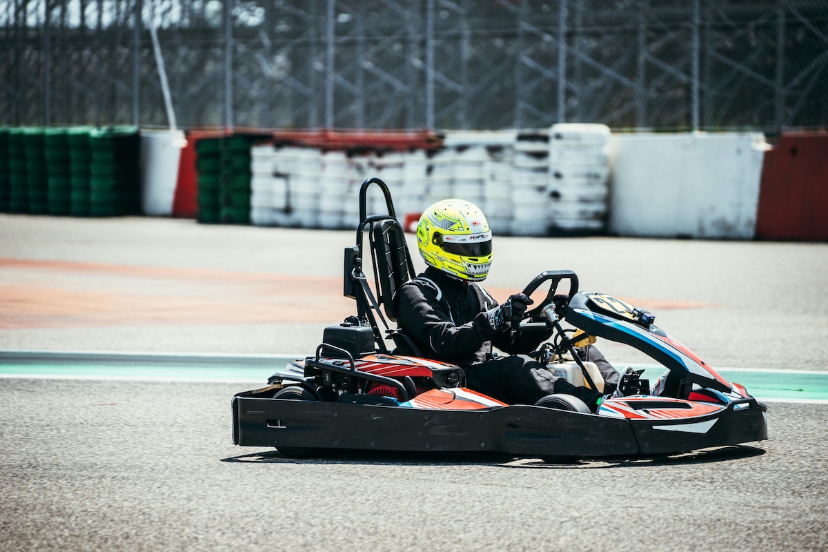 man is racing a go kart through the course