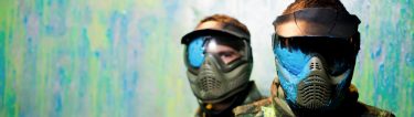 two guys covered in paint with paintball gear