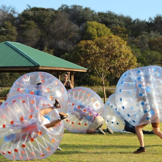guys playing outside with bubble soccer